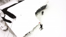 Aerial photo of two conservation officers on snowshoes outside a snow-covered house