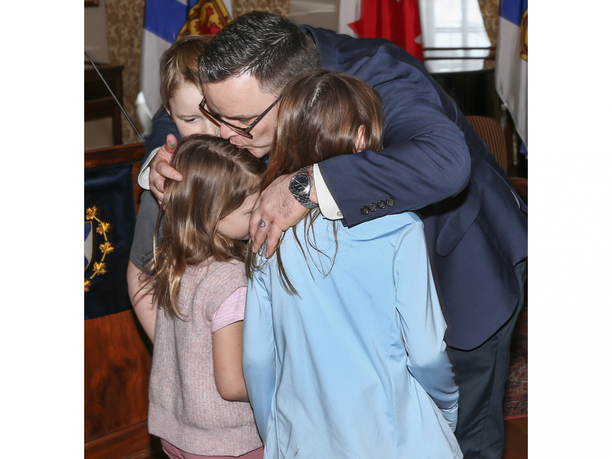 Photo of Community Services Minister Brendan Maguire hugging his three children.