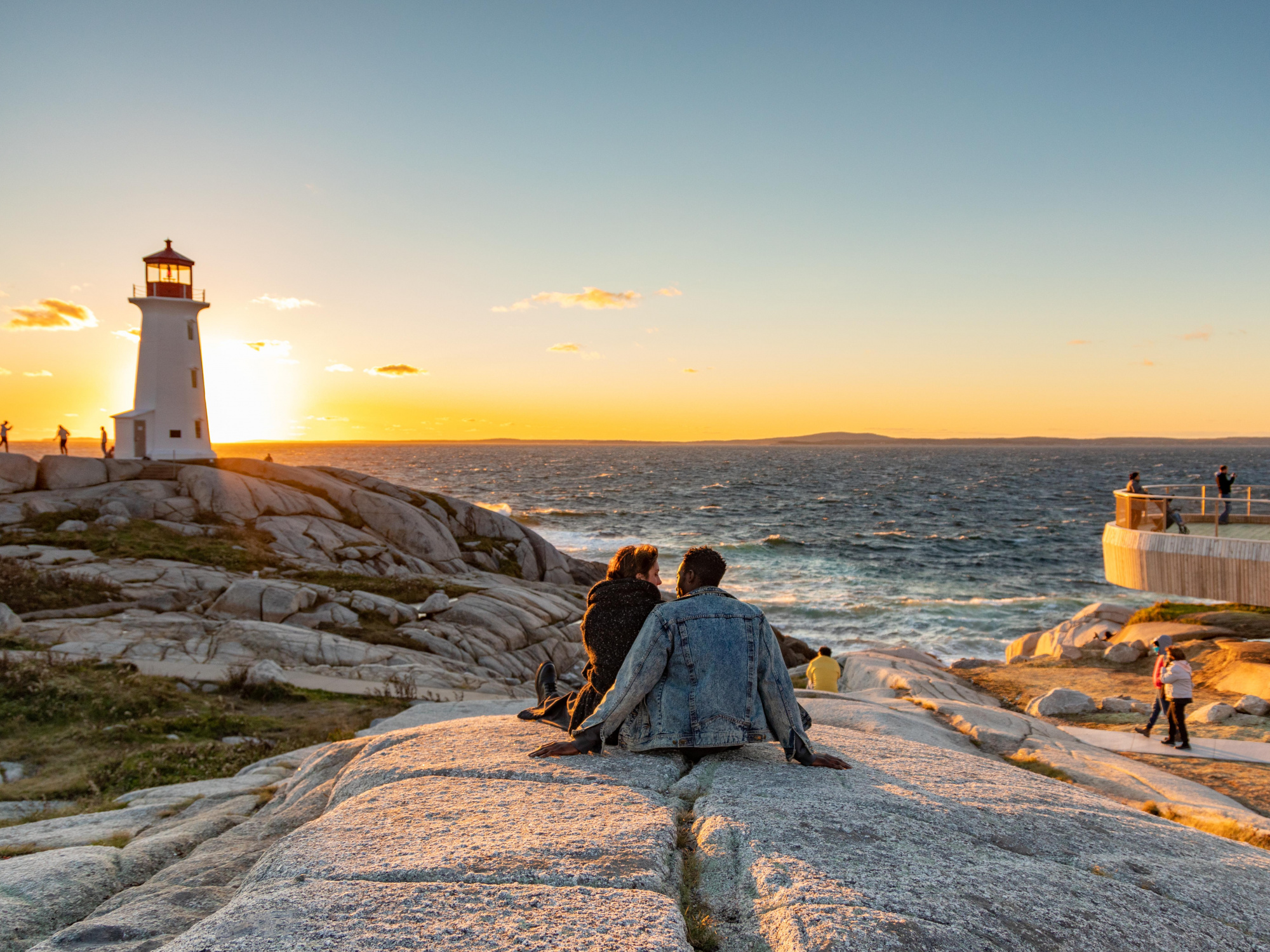 Photo of people visiting the Peggys Cove lighthouse site (Tourism Nova Scotia/Acorn Art & Photography)