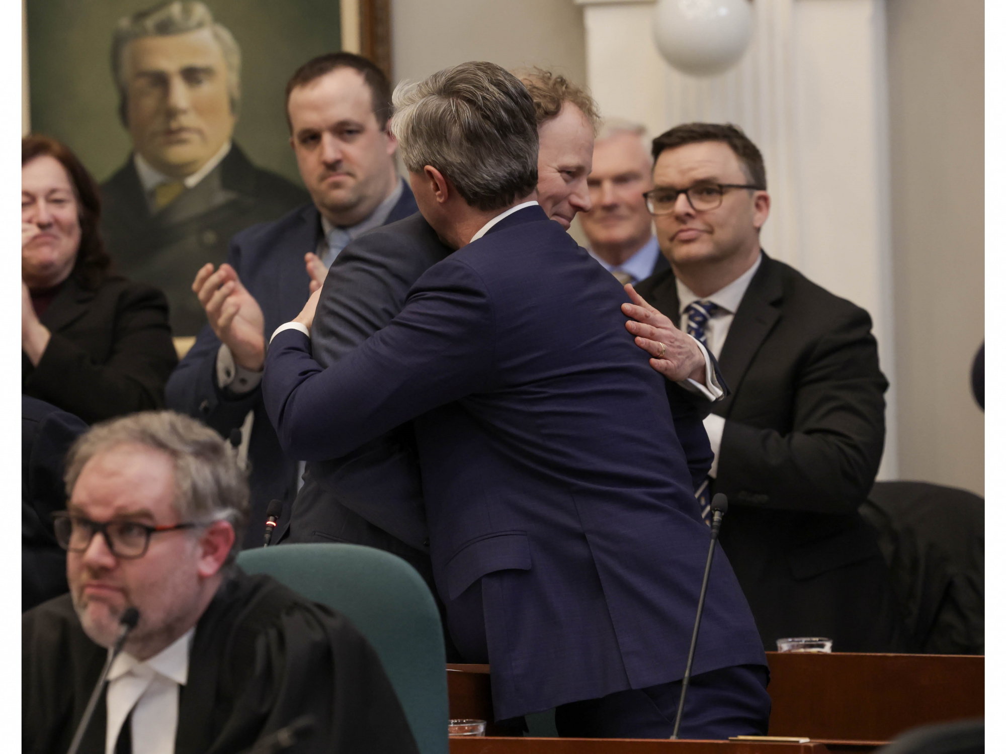 Finance and Treasury Board Minister Allan MacMaster embrace after the Minister's budget speech 