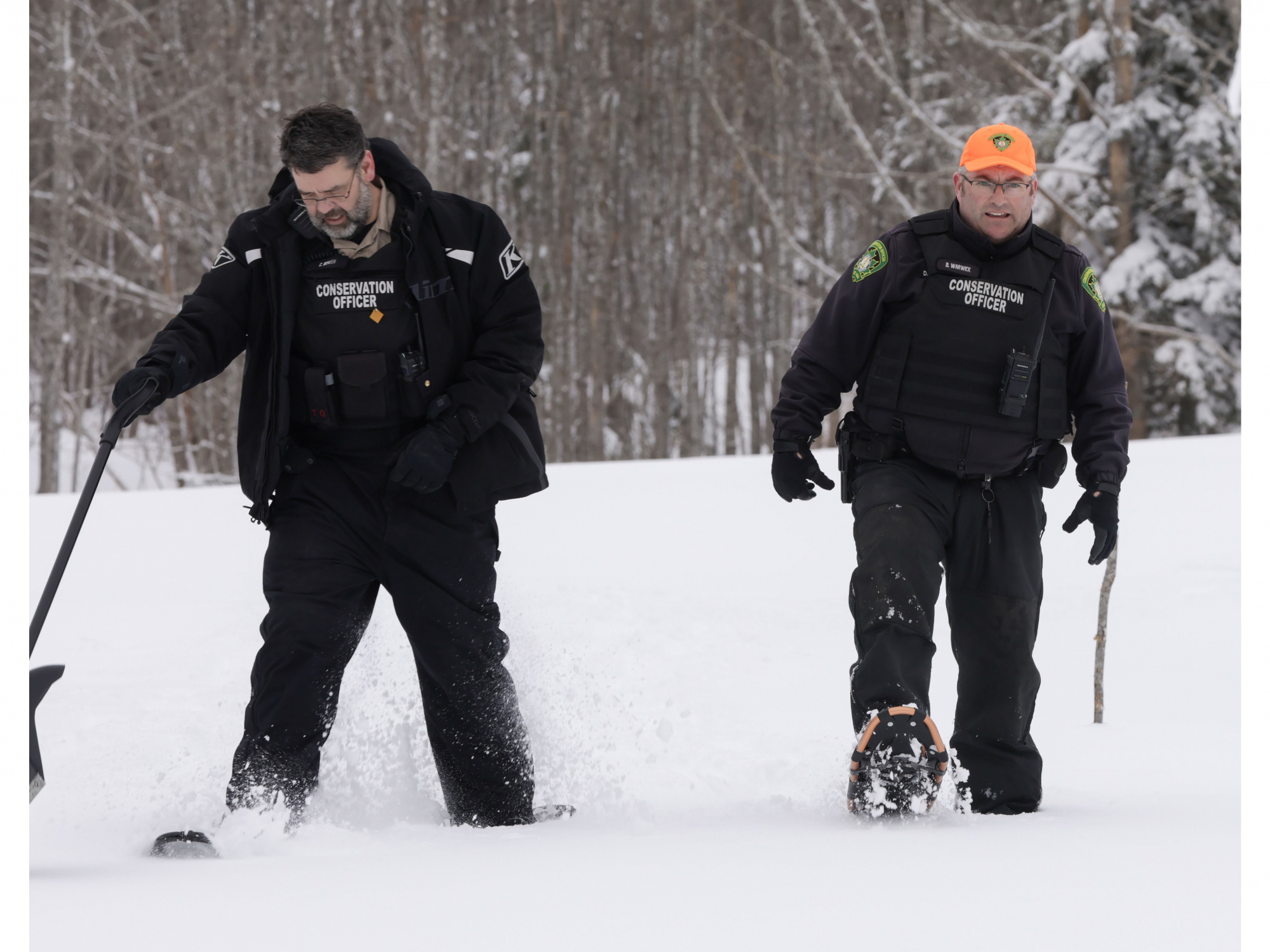 Photo of conservation officers on snowshoes walking 