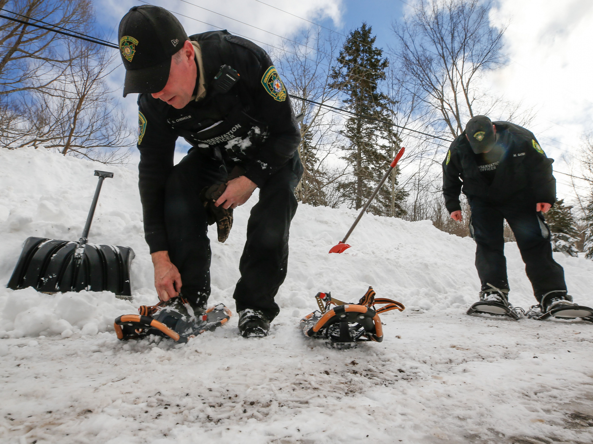 Photo of two conservation officers putting on snowshoes