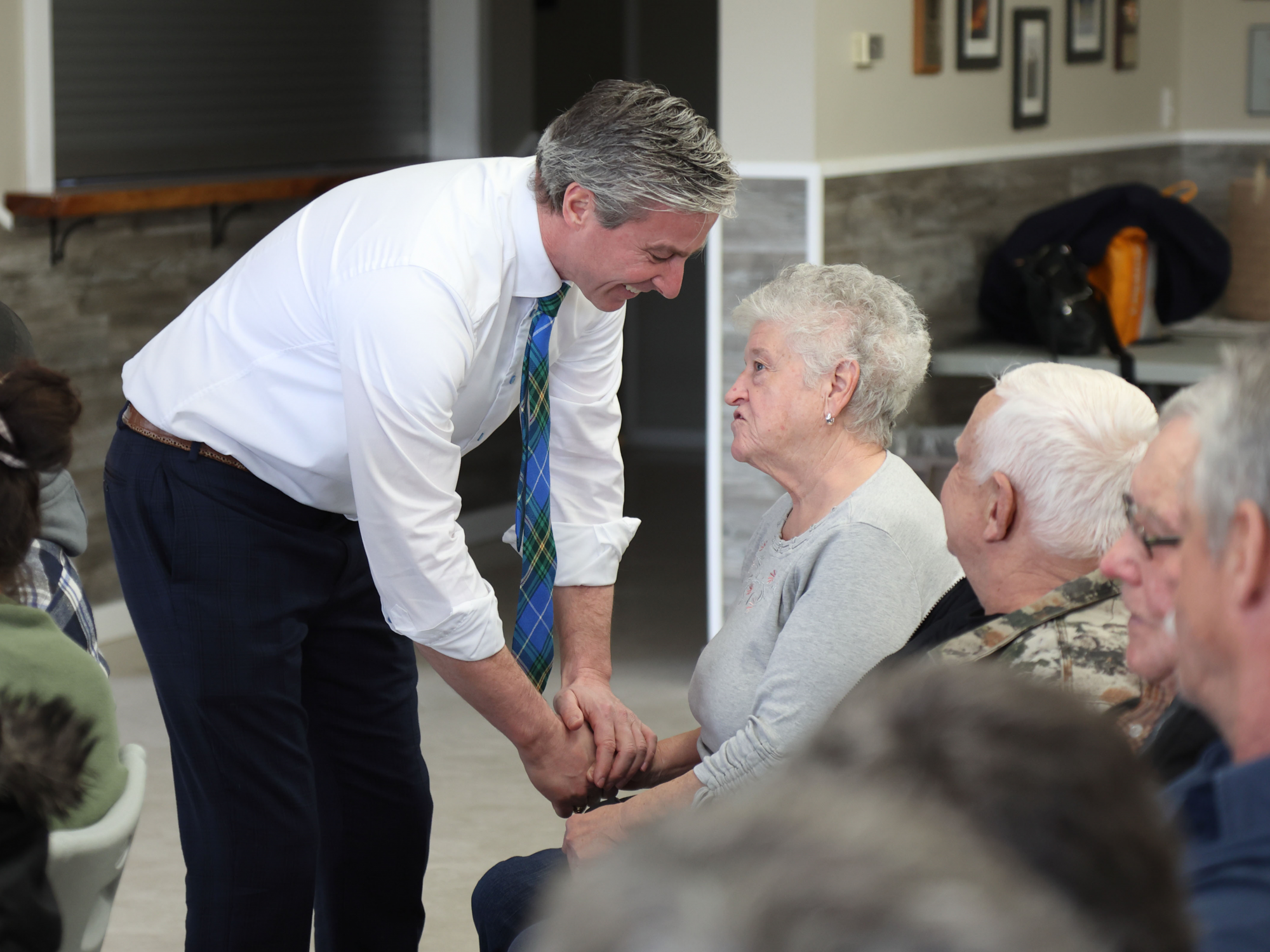 Photo of Premier Tim Houston speaking to a senior citizen