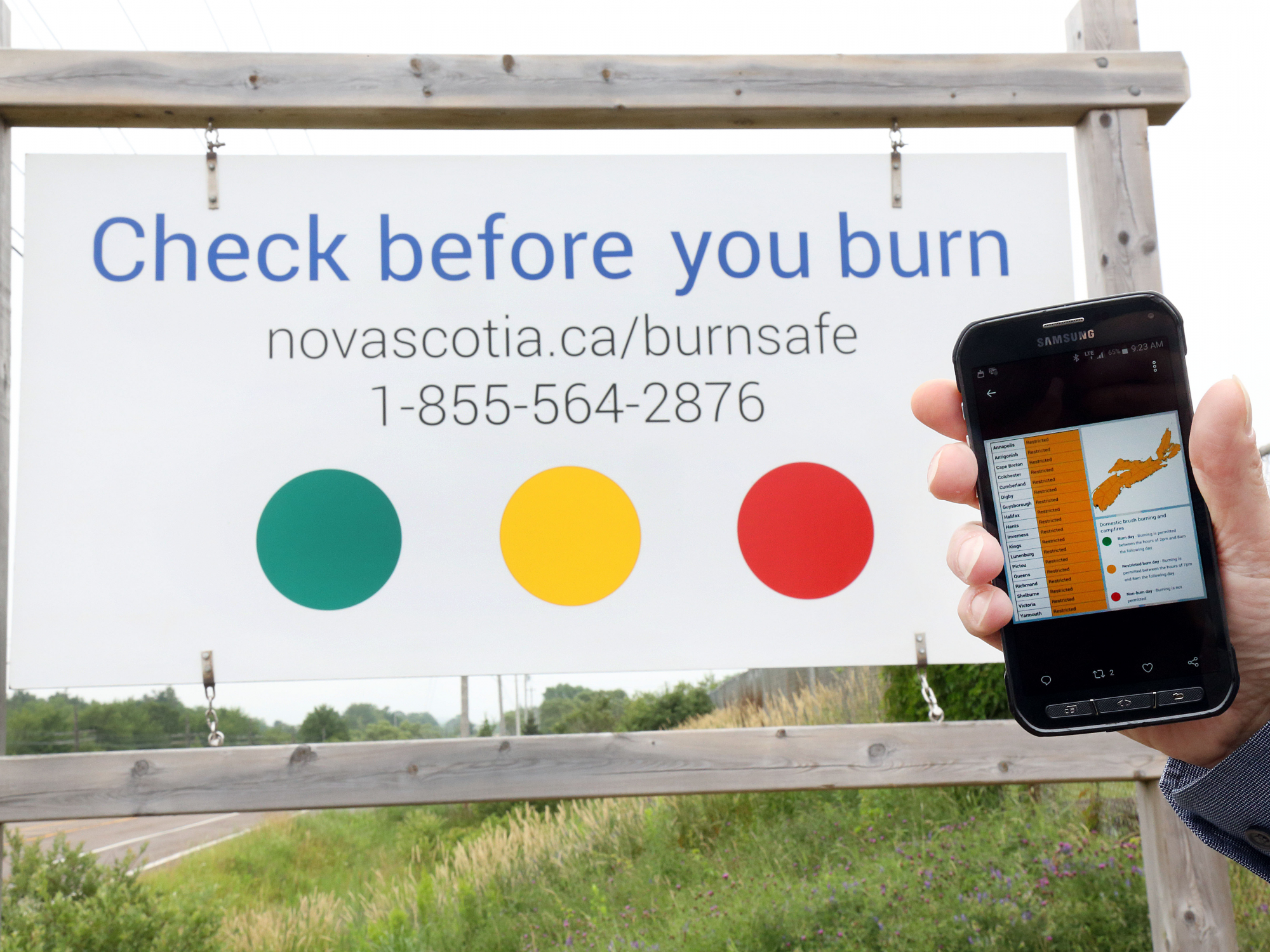 Photo of BurnSafe sign and someone holding a phone open to the BurnSafe map