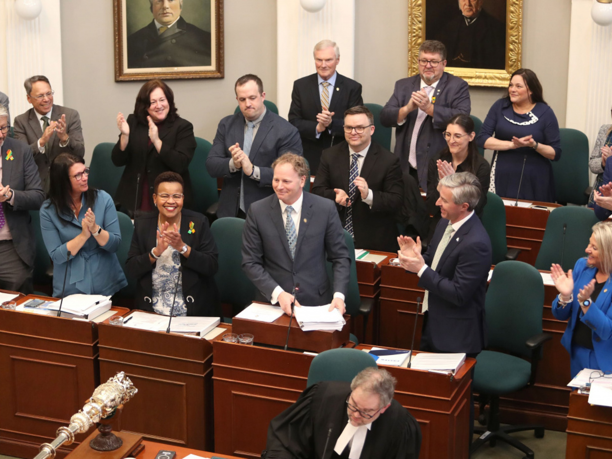 Photo of Finance Minister Allan MacMaster and government members in legislative chamber