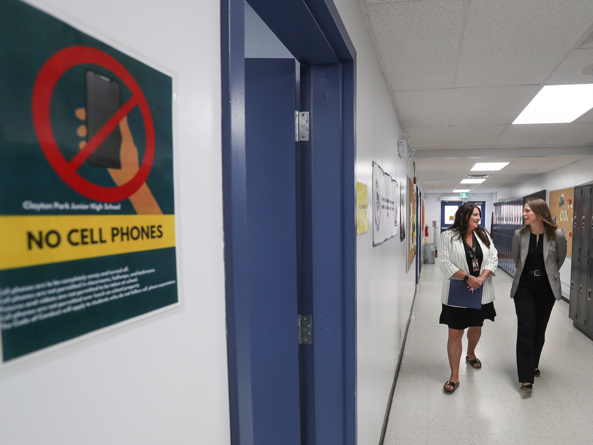 Photo of Education and Early Childhood Development Minister Becky Druhan walkin fin school hallway with Clayton Park Junior High Principal Trina Canavan