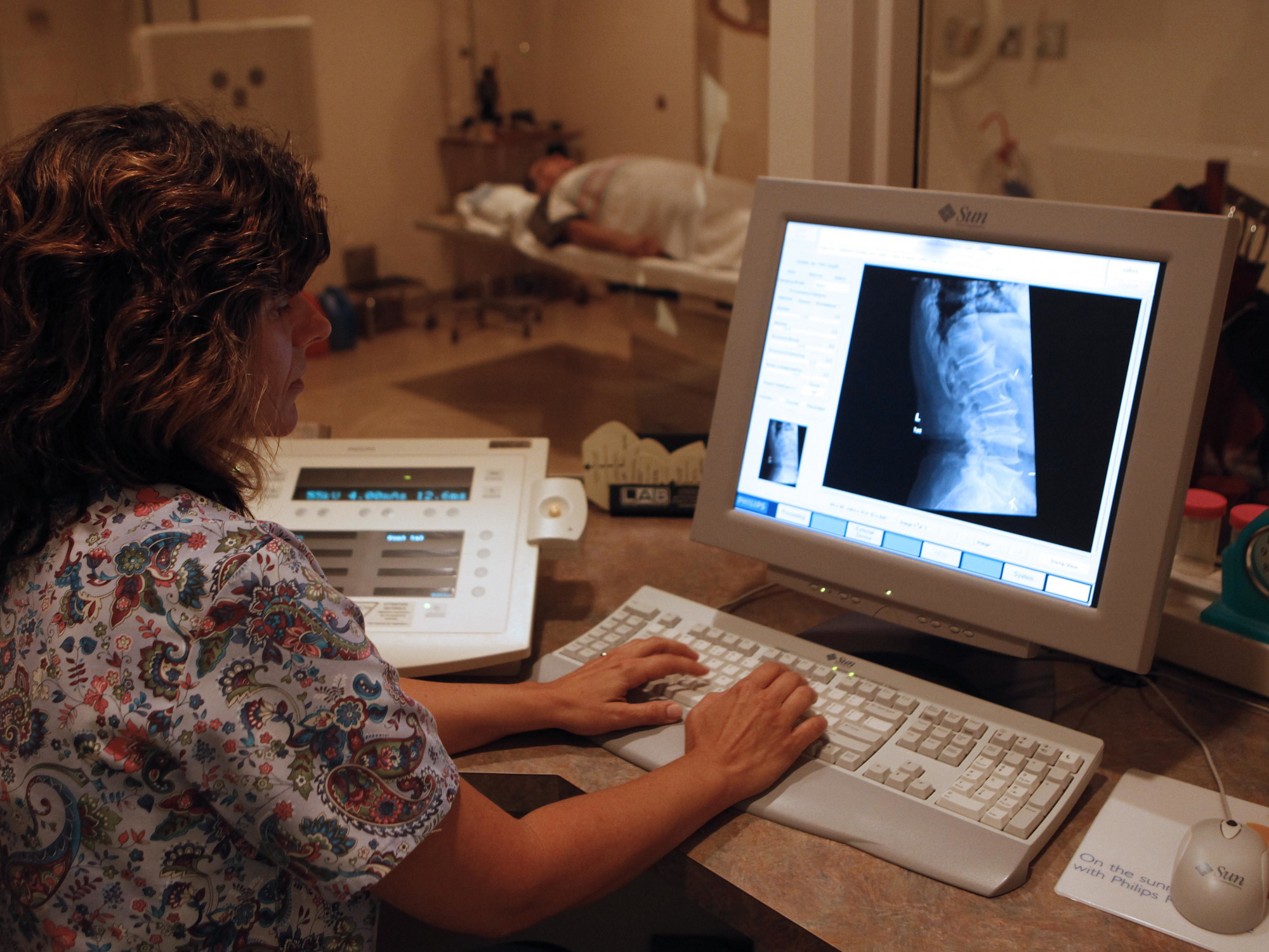 Photo of technician looking at an X-ray on a computer