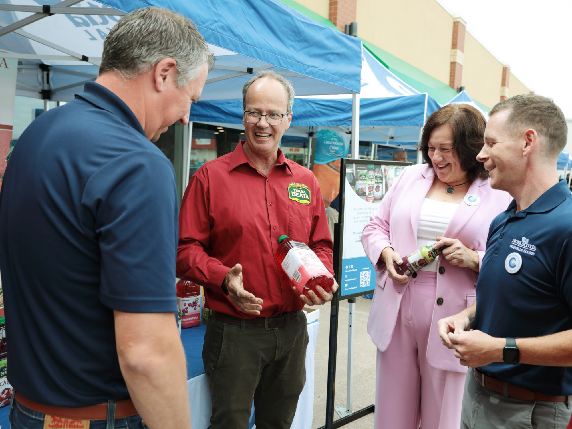 Photo of Agriculture Minister Greg Morrow, Economic Development Minister Susan Corkum-Greek and Service Nova Scotia Minister Colton LeBlanc talking to a vendor