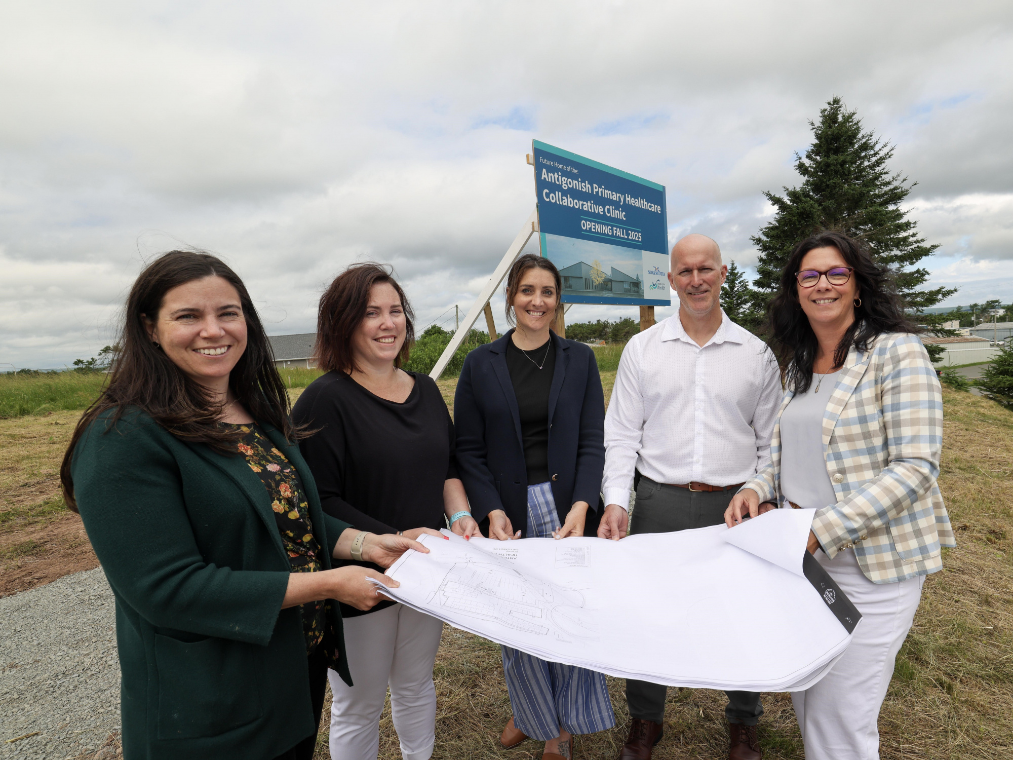 Photo of Health and Wellness Minister Michelle Thompson, local doctors and Nova Scotia Health officials holding a plan of the new Antigonish collaborative care clinic