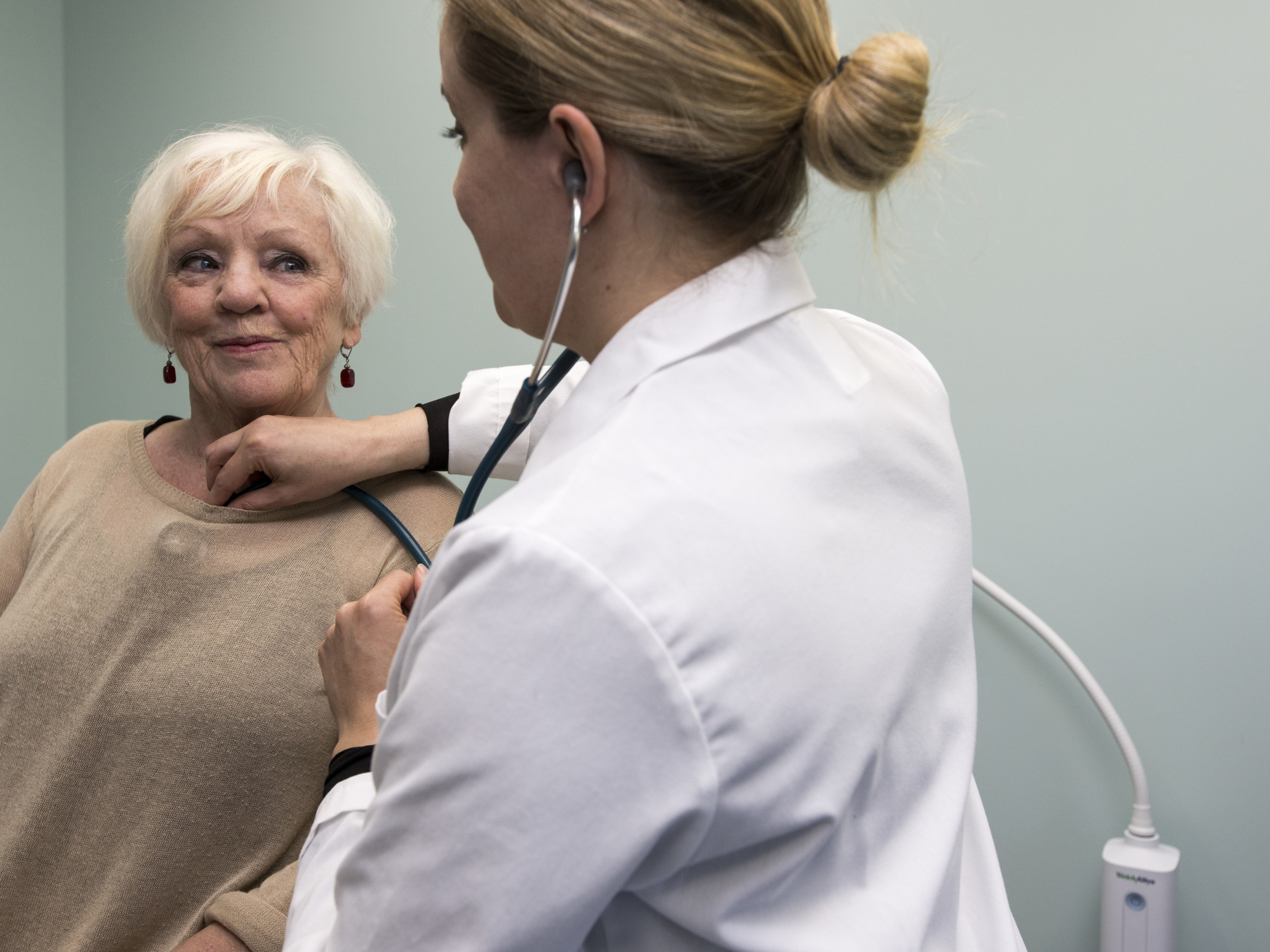 Photo of a doctor with a stethoscope examining a patient