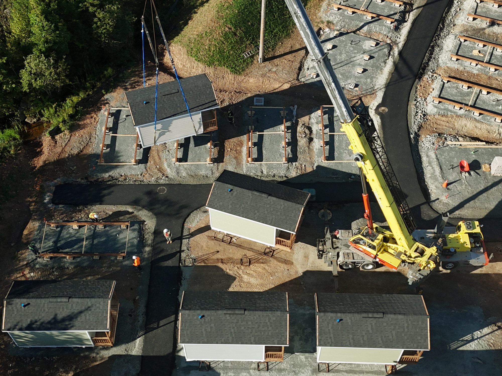 Photo of a crane lowering a tiny home