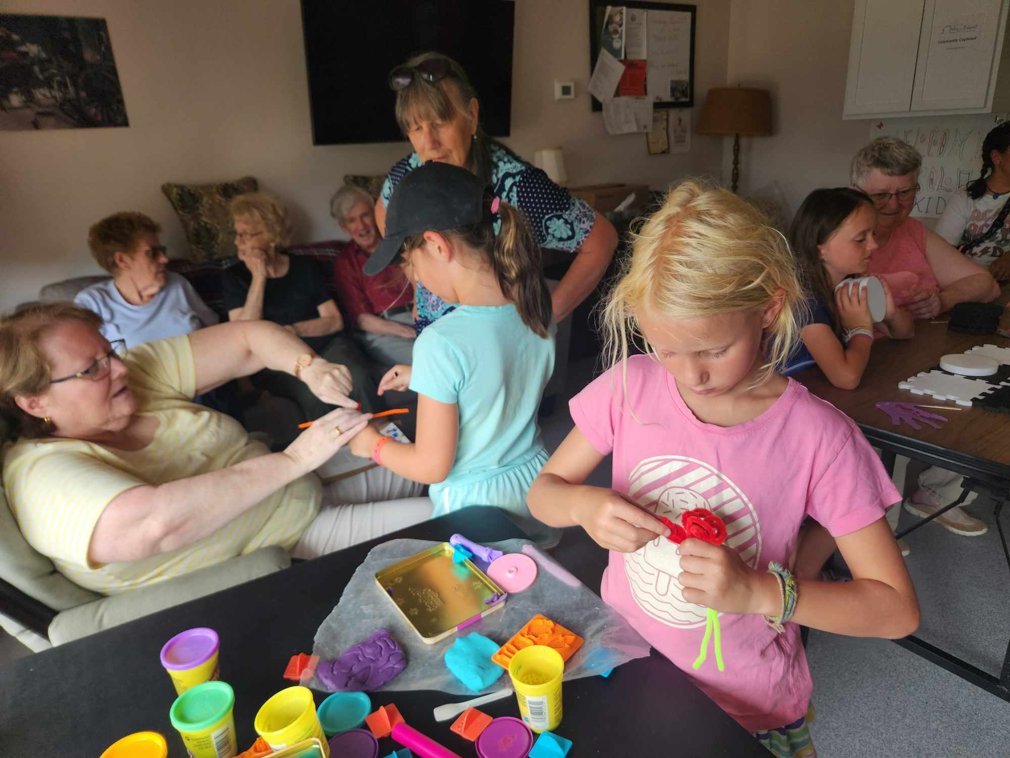 Alt text: Photo showing a group of adults and children doing crafts together.