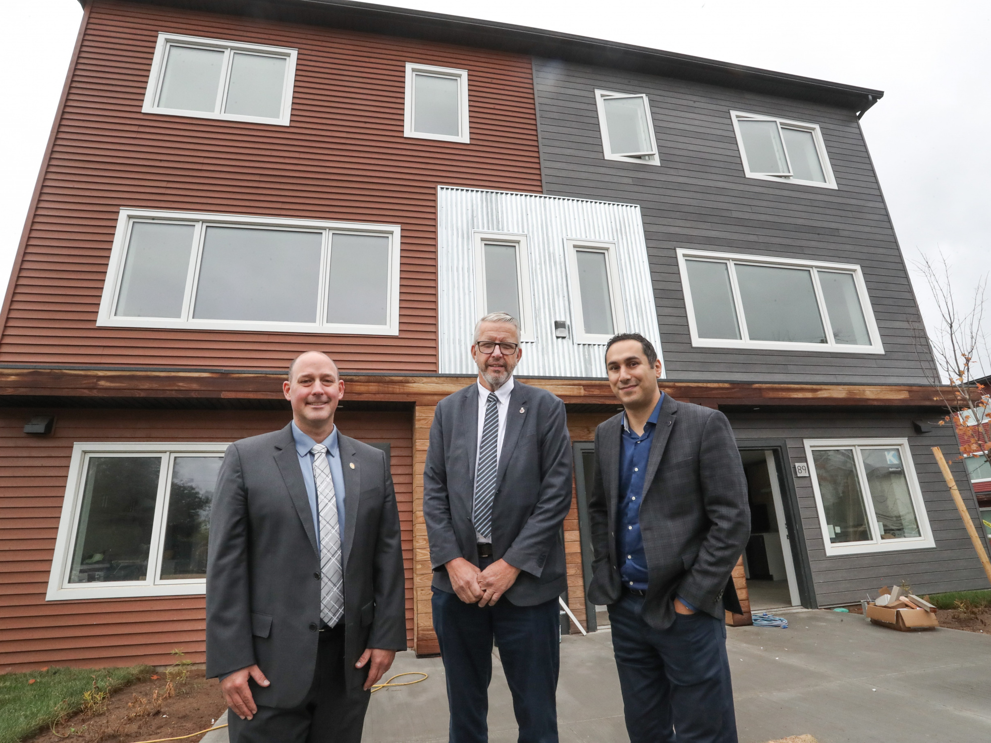 Minister Timothy Halman and Minister John Lohr pose with Michael Kabalen in Dartmouth housing announcement