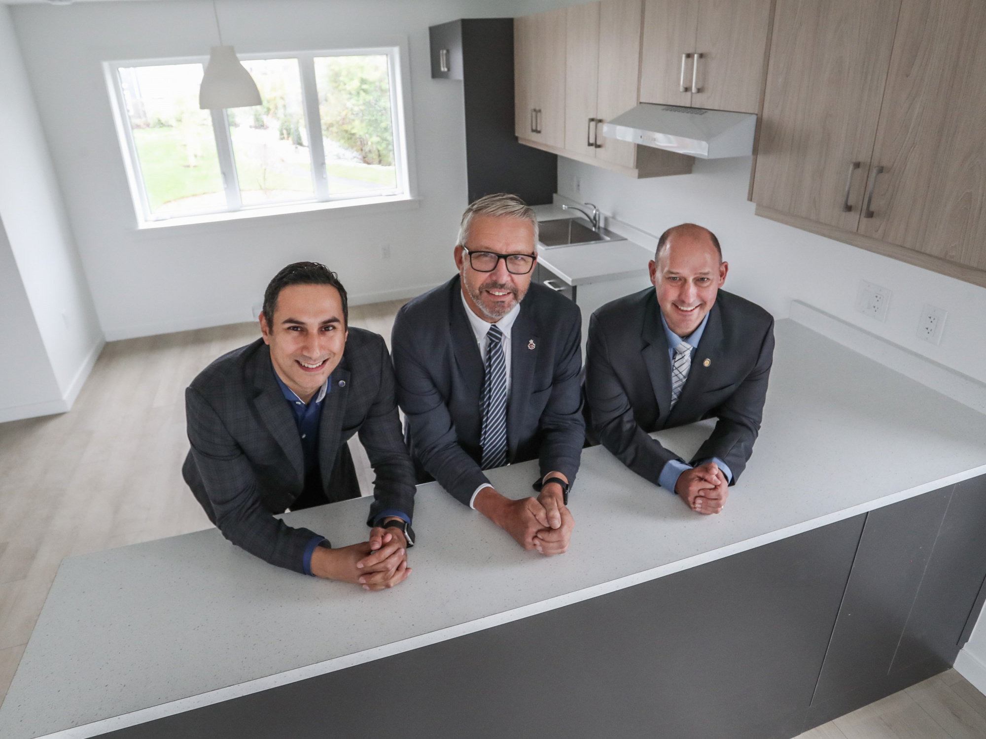 Michael Kabalen, Minister John Lohr and Minister Timothy Halman pose inside the kitchen  Dartmouth announcement