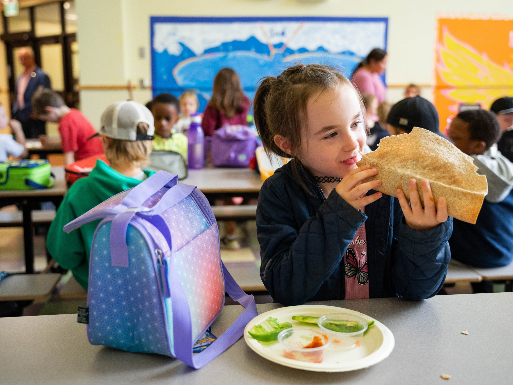 Photo of a girl eating a taco at school