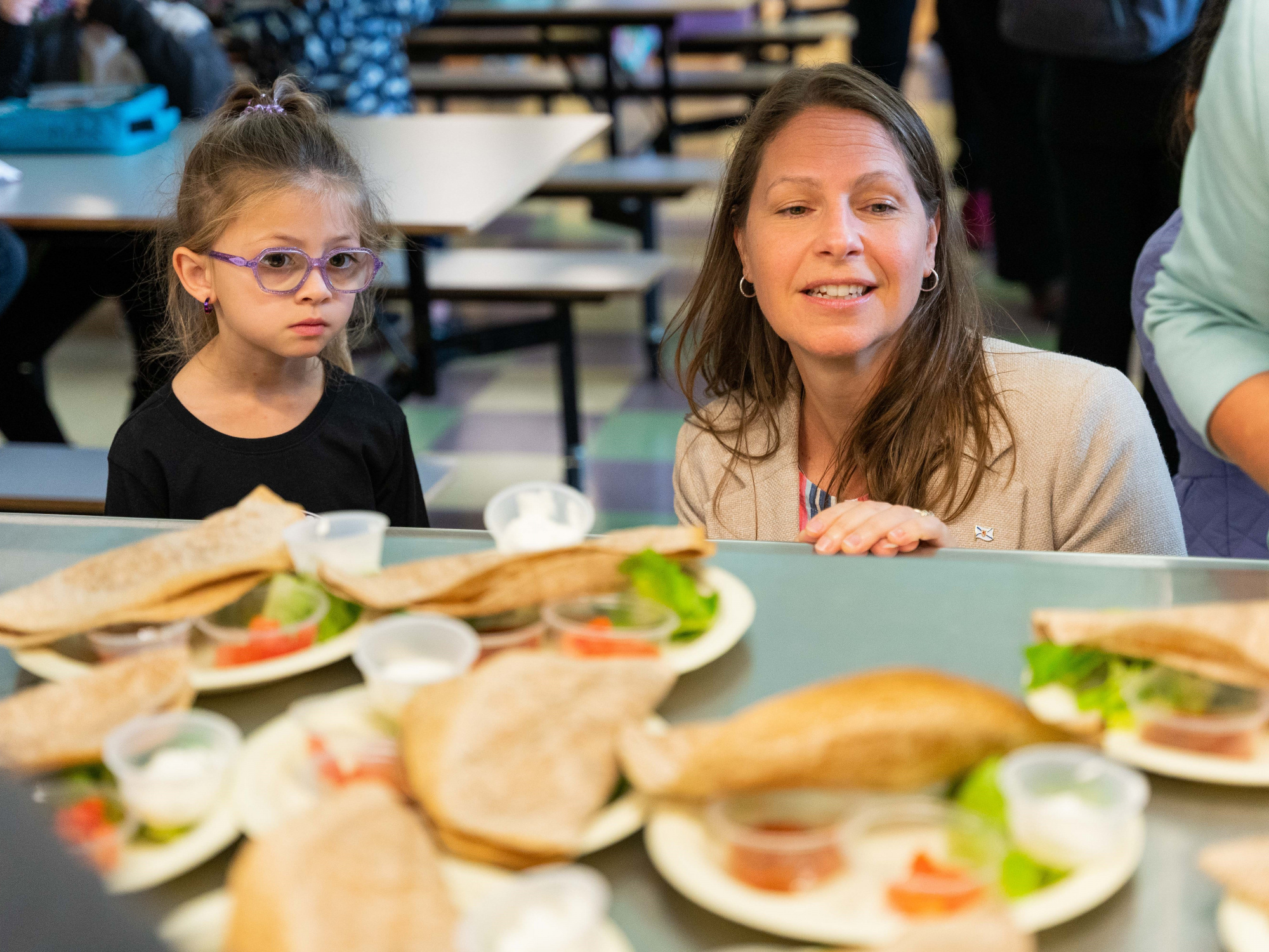 Photo of Education and Early Childhood Development Minister Becky Druhan looking at lunches with a student