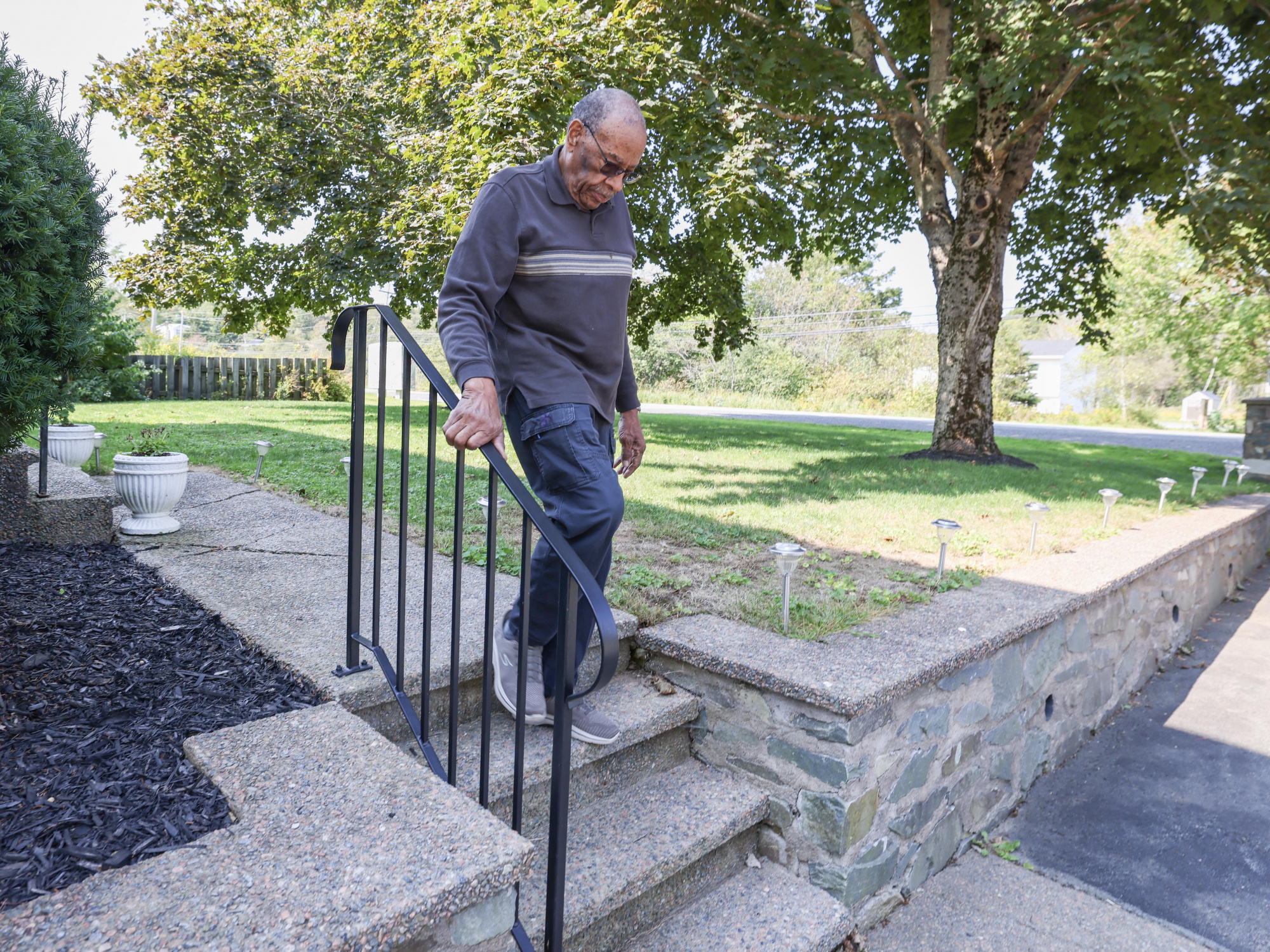 Photo of a man walking down stairs outside a home