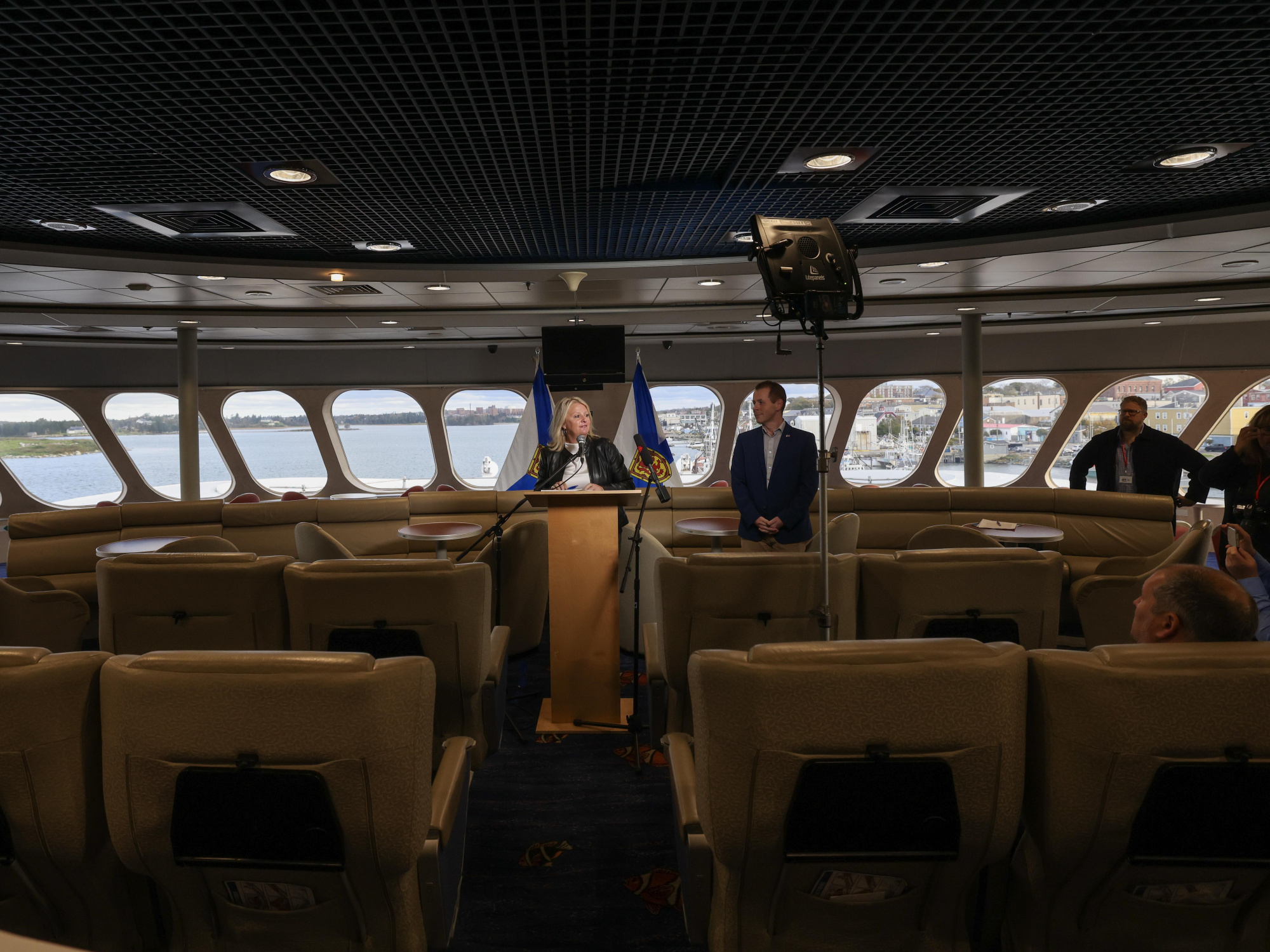 Photo of Public Works Minister Kim Masland standing at a podium aboard the Cat ferry, along with Service Nova Scotia Minister Colton LeBlanc