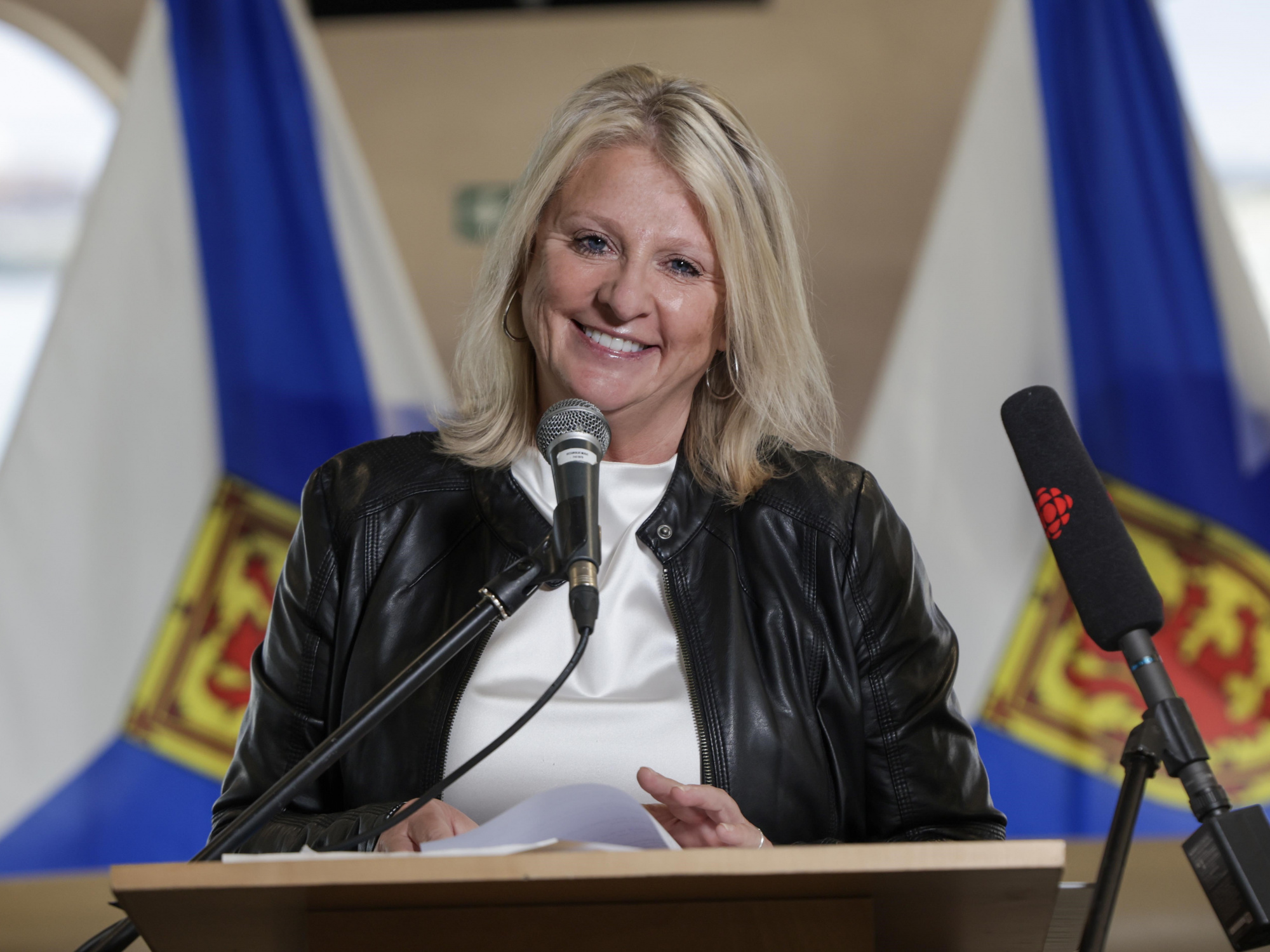 Public Works Minister Kim Masland stands at a podium 