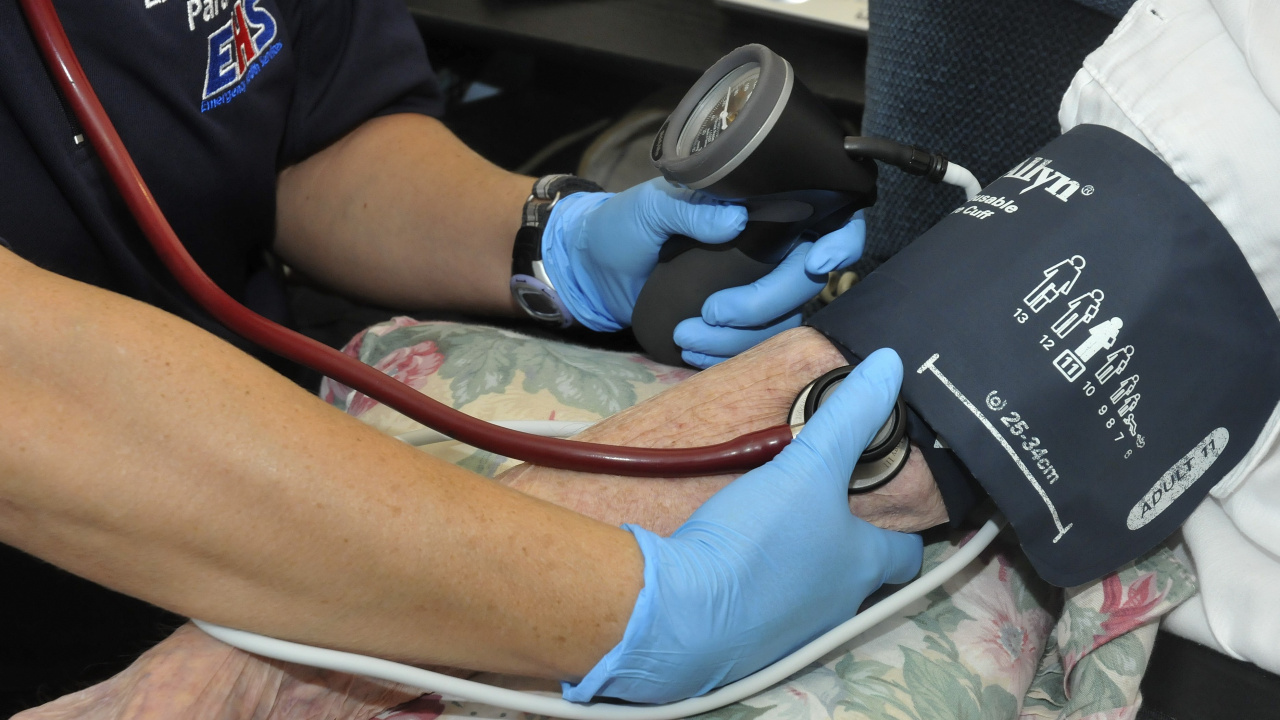 Photo showing the hands of a paramedic taking a patient's blood pressure