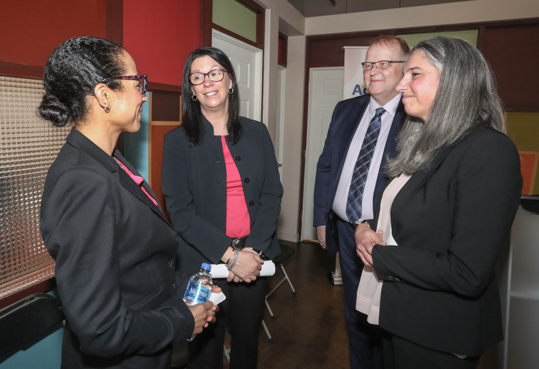 A photo showing four announcement participants chatting amongst themselves