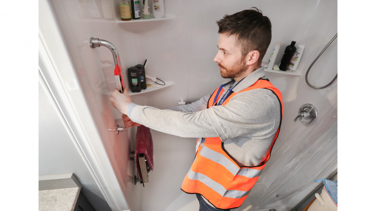 Photo of handyman installing a grab bar in a bathroom