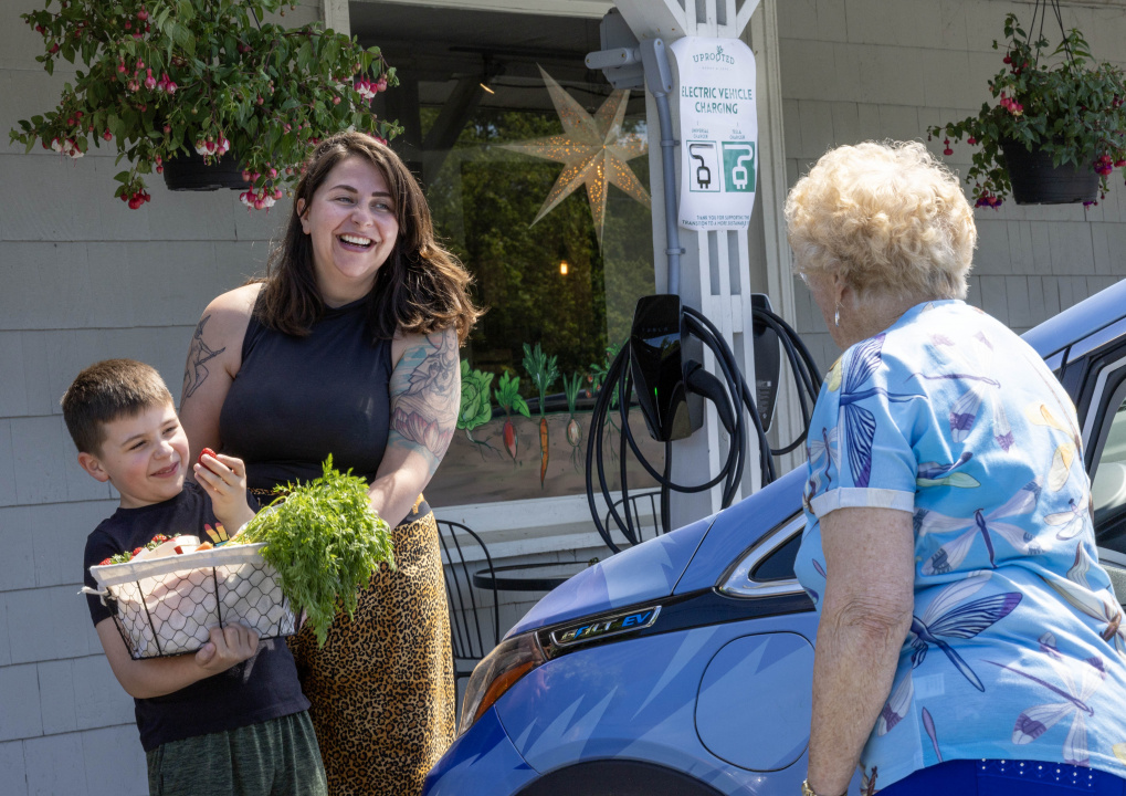 Photo of people and car at an electric vehicle charging station