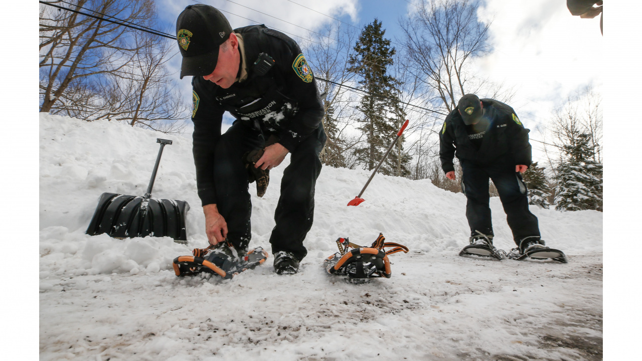 Photo of two conservation officers putting on snowshoes