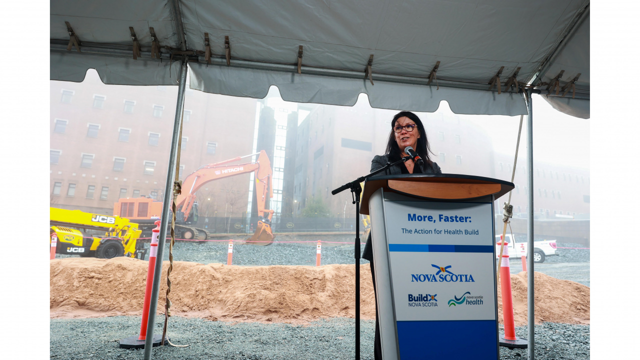 Photo of Health and Wellness Minister Michelle Thompson at a podium under a tent