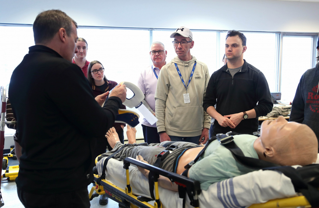 The first class of emergency medical responders using a dummy on a stretcher to practice their lessons