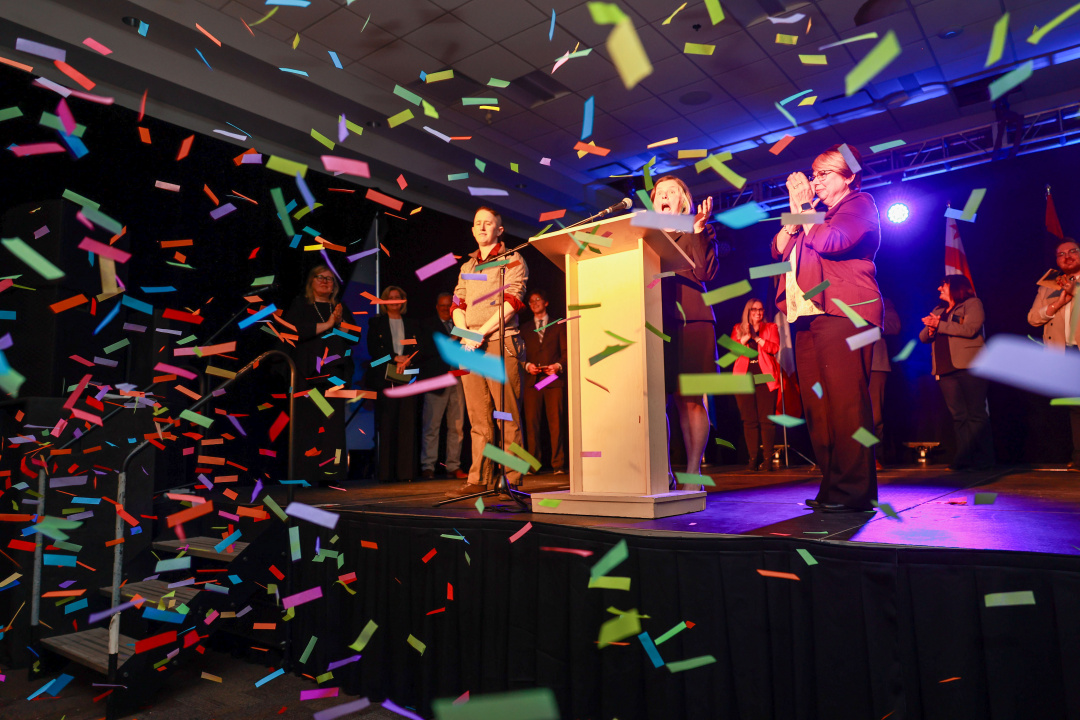 Krista Jangaard, IWK Health CEO (at podium), reacts as confetti is released to celebrate the announcement