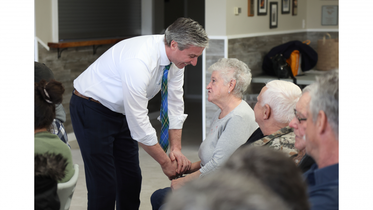 Photo of Premier Tim Houston speaking to a senior citizen