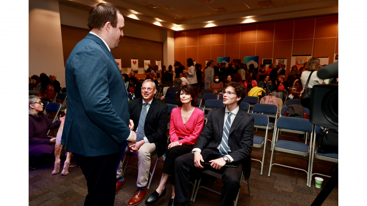 Photo of Brian Comer, Minister of Addictions and Mental Health, speaks with young people at an announcement