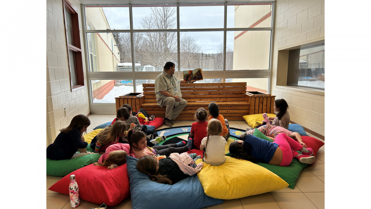 Photo of Phillip Prosper, a Mi’kmaw support teacher at Whycocomagh Education Centre in Cape Breton, reading to Grade Primary students