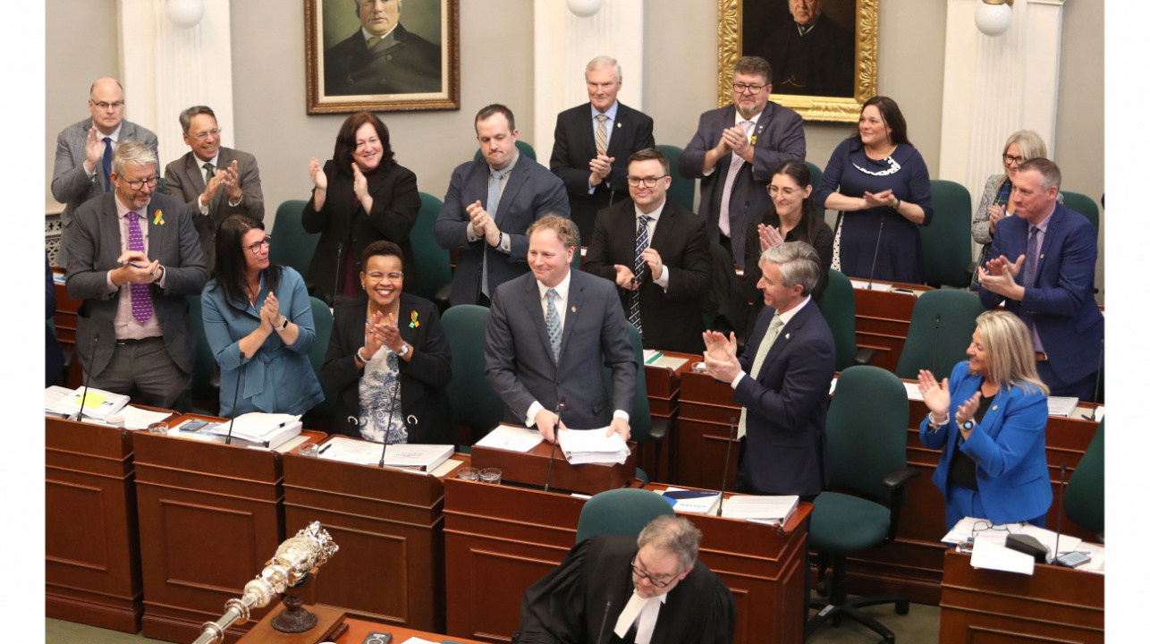 Photo of Finance Minister Allan MacMaster and government members in legislative chamber