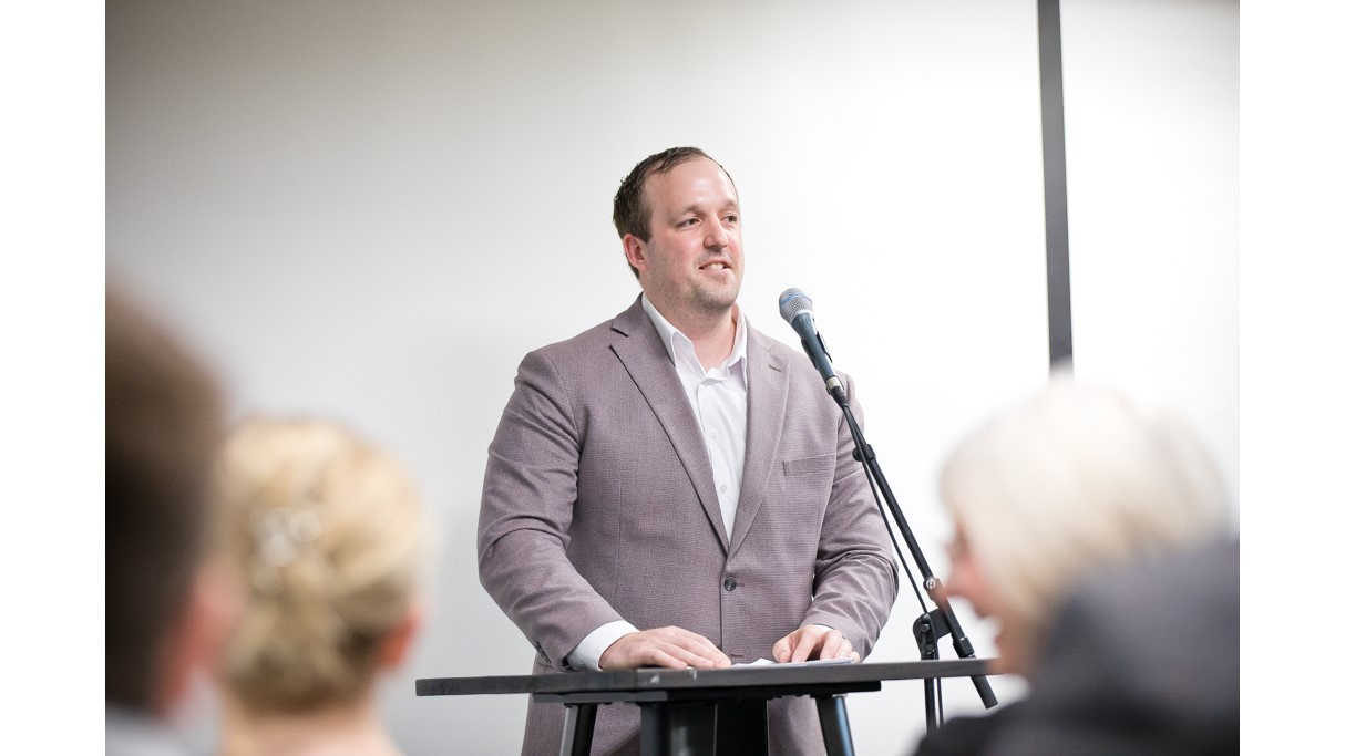 Photo of Addictions and Mental Health Minister Brian Comer at a podium