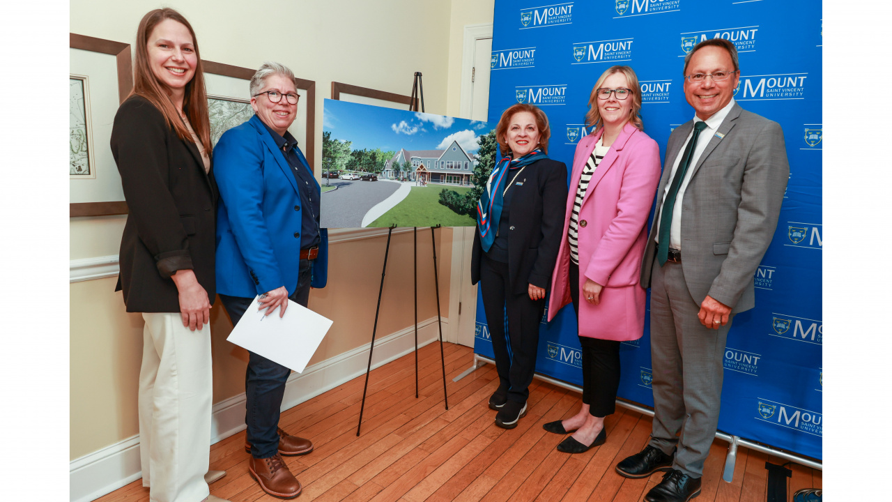 Photo of ministers and partners around a rendering of a new child-care centre