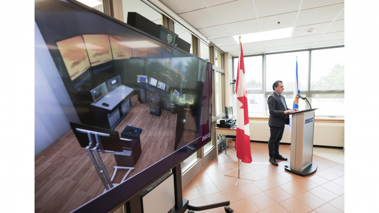 Photo of fisheries simulator on a screen and Shelburne MLA Nolan Young at a podium in the background