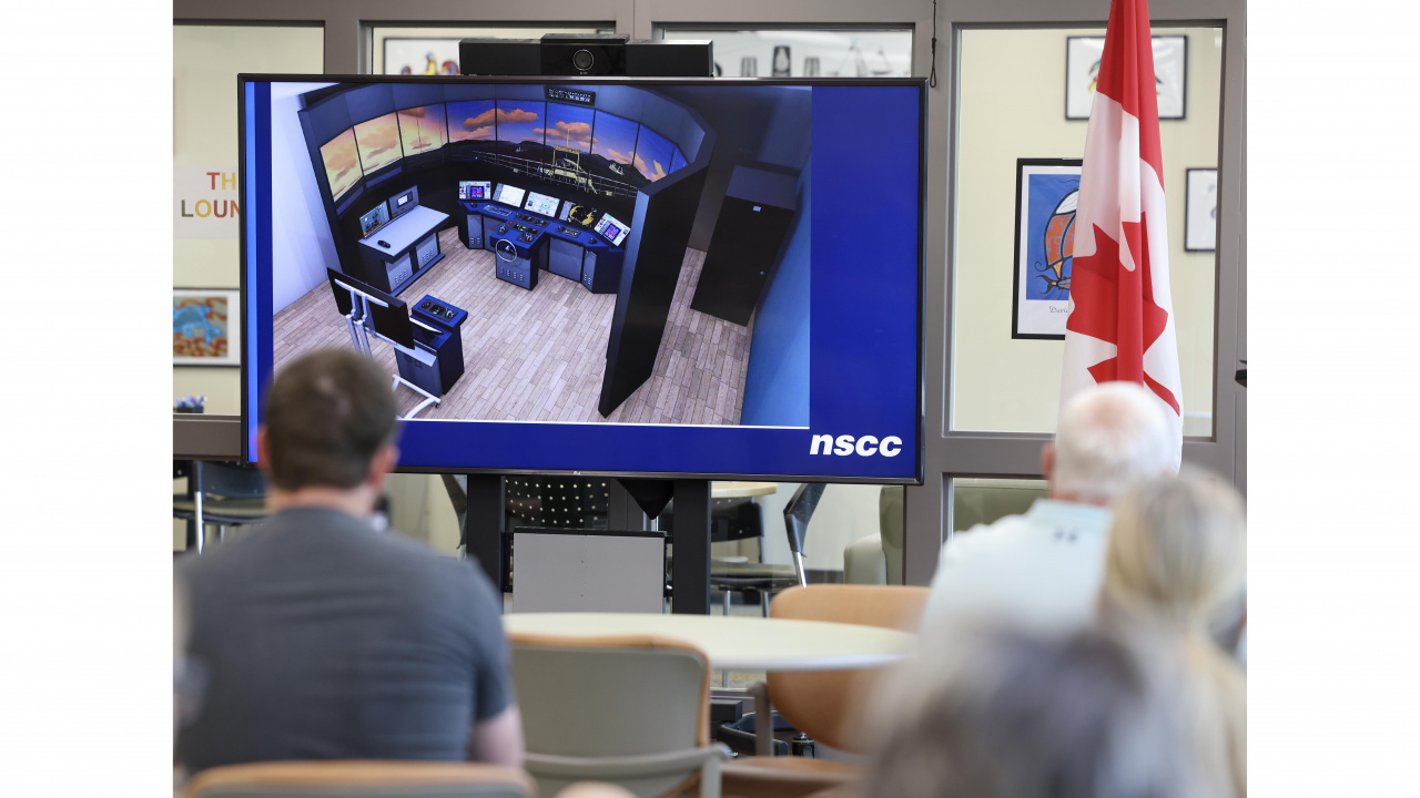 Photo people looking at a screen showing a marine navigation simulator