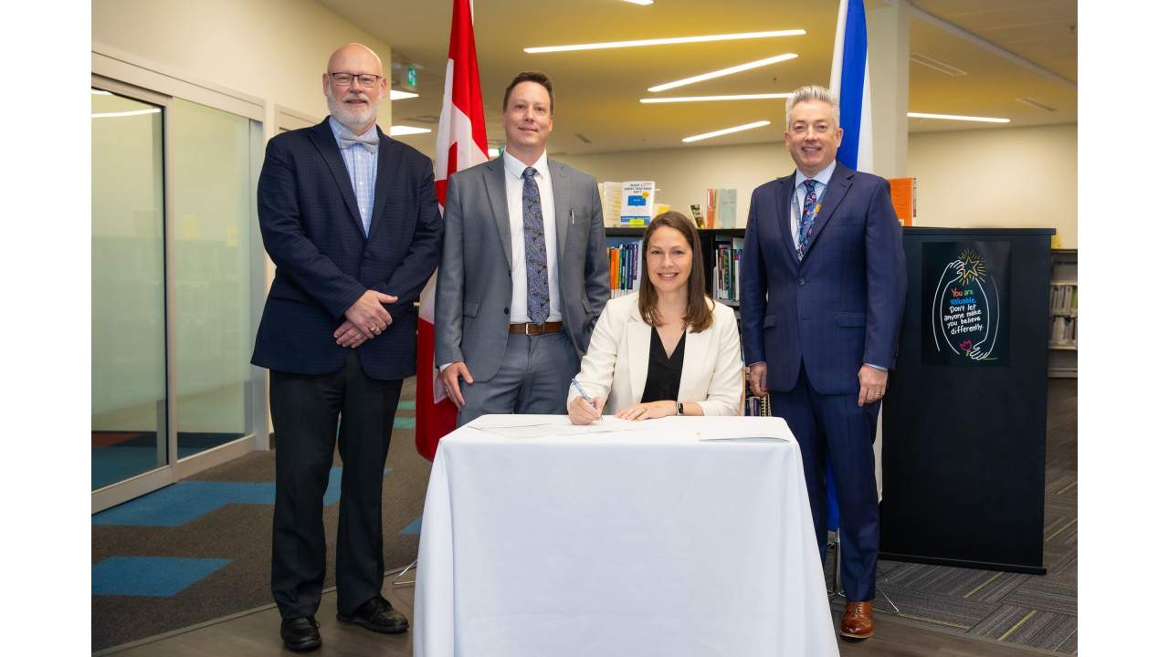 Photo of Education and Early Childhood Development Minister Becky Druhan at a small table and three officials around her