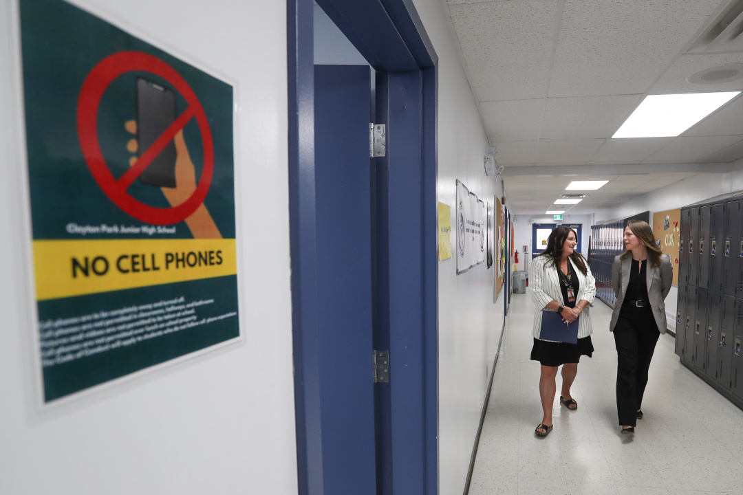 Photo of Education and Early Childhood Development Minister Becky Druhan walkin fin school hallway with Clayton Park Junior High Principal Trina Canavan