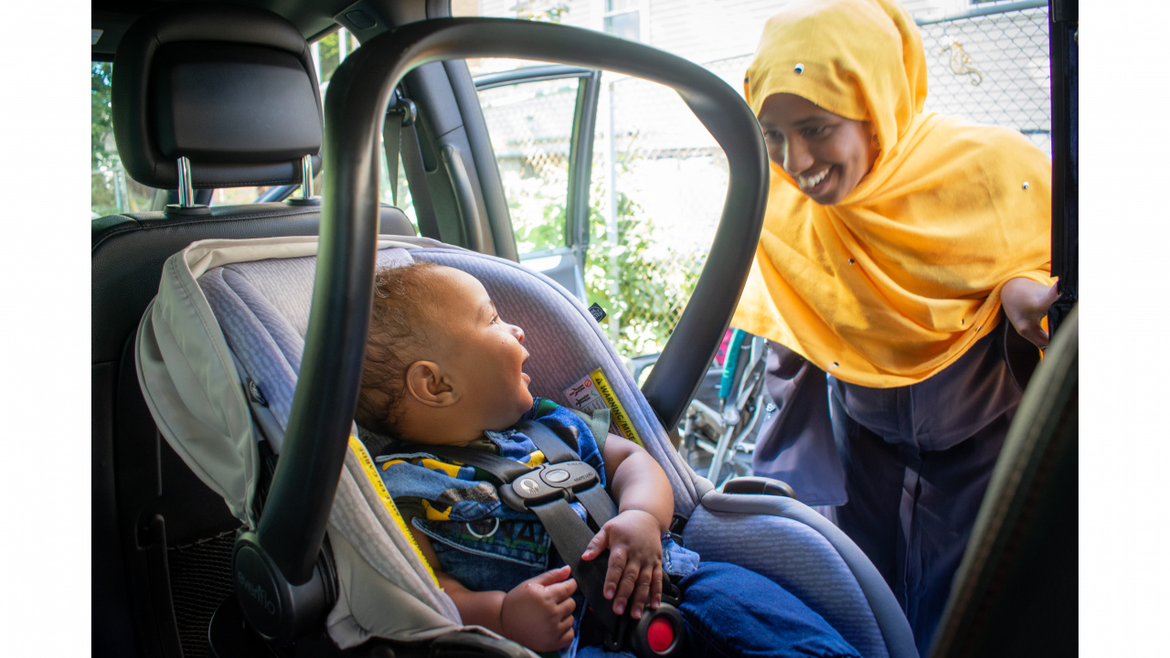Photo of child in a car seat and adult smiling