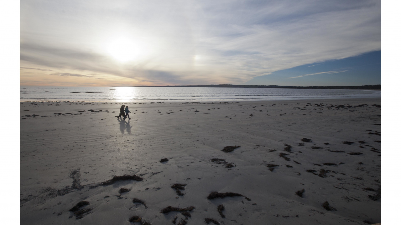 Photo of three people walking on Crescent Beach