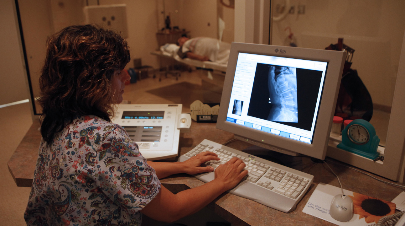 Photo of technician looking at an X-ray on a computer