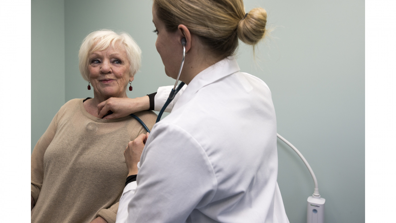 Photo of a doctor with a stethoscope examining a patient