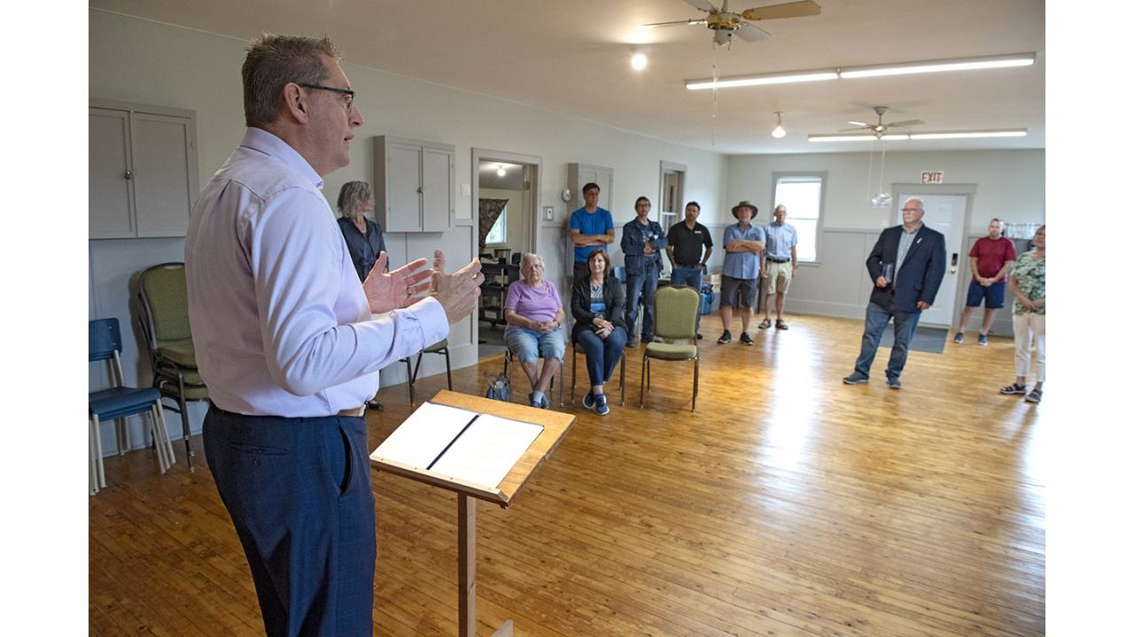 Photo of MLA Chris Palmer at a short podium speaking to people in a community hall