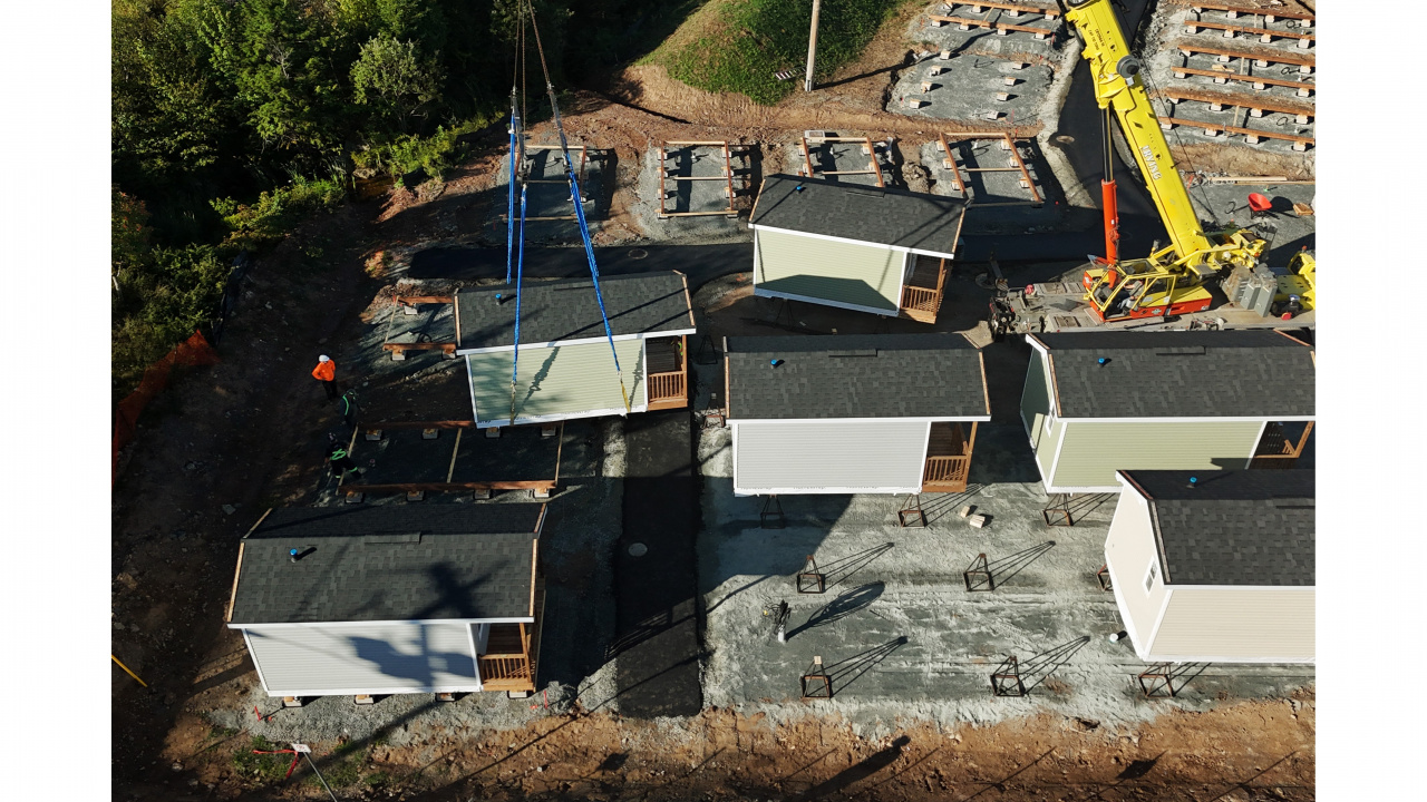 Photo of a crane lowering a tiny home