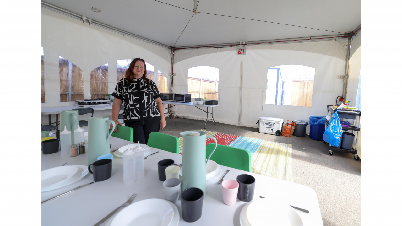 Photo of a woman in a common eating area at a shelter village