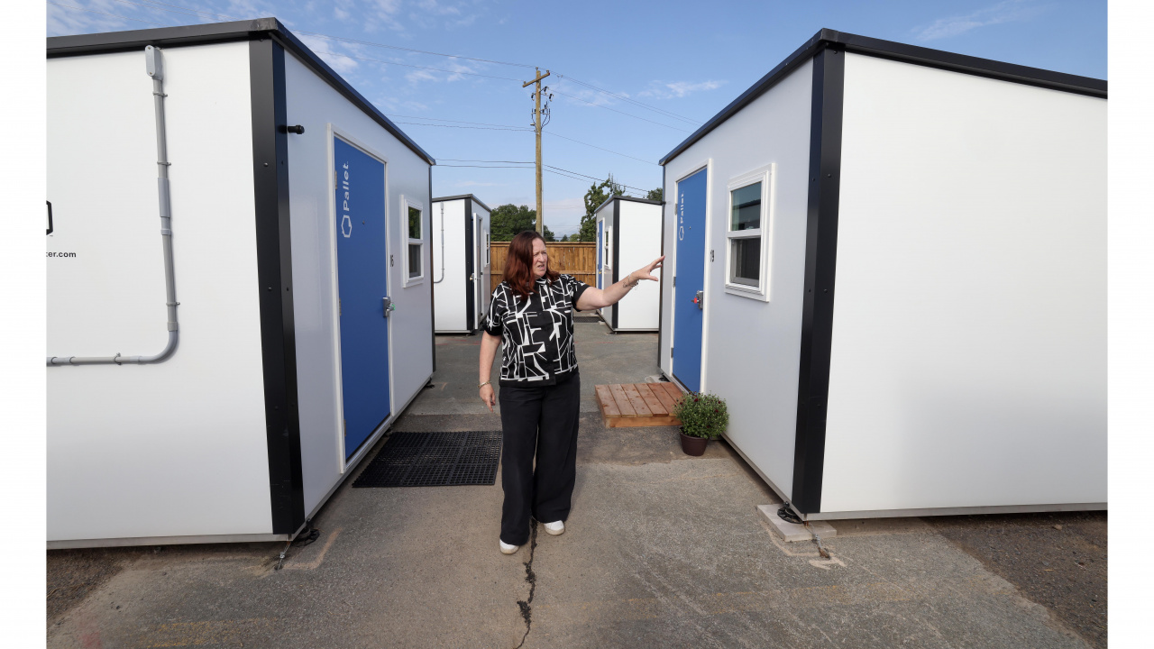 Photo of a woman standing between Pallet shelters