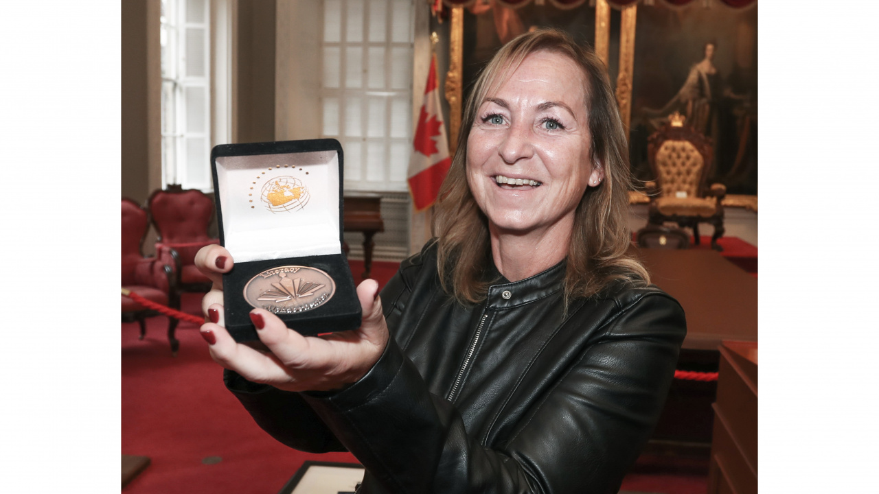 Photo of CoF Literacy Award recipient Lorenda Harper holding up her medal